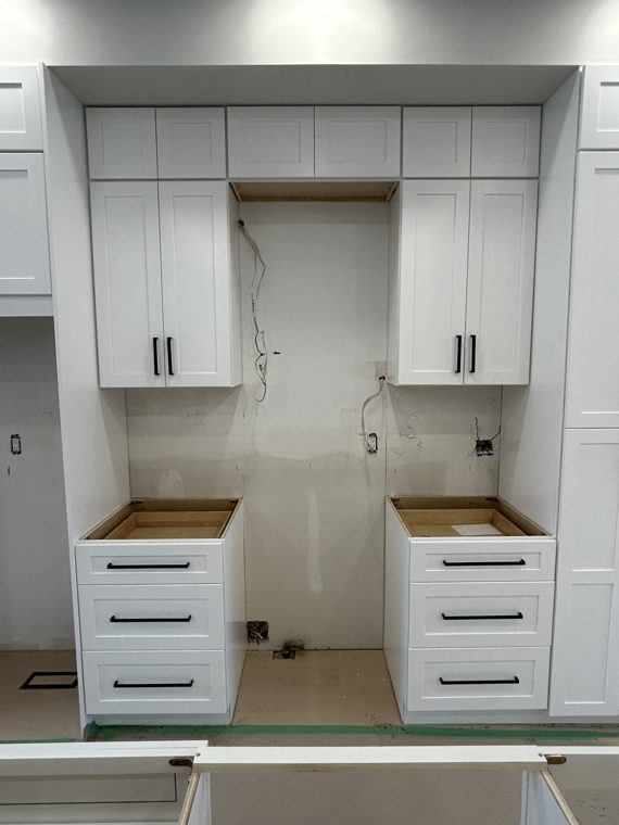 Cabinet drawers and tall pantry units around the cooking area