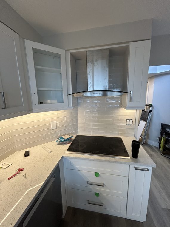 Cooking area and corner countertop in a white kitchen