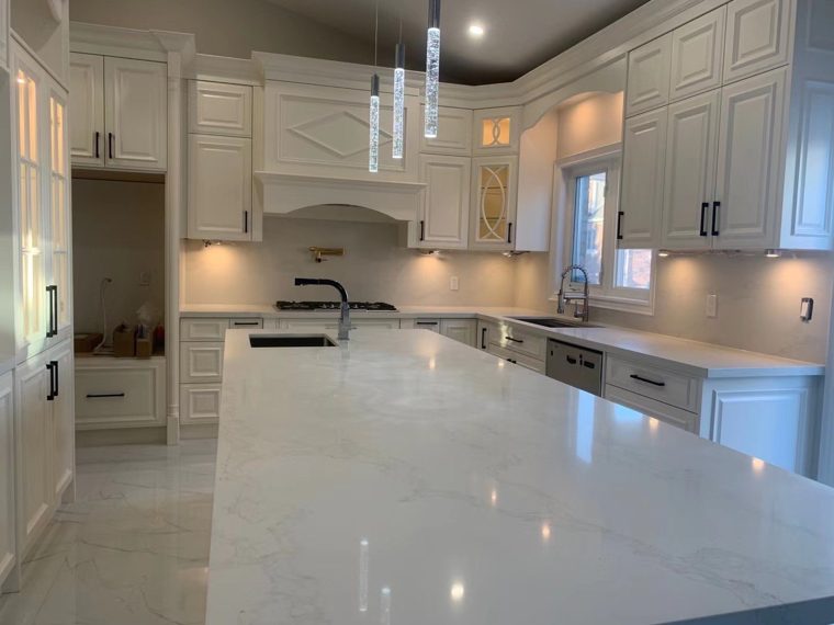 White kitchen cabinets with glass doors and a broad countertop