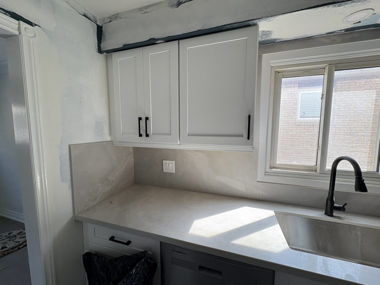 White upper cabinets and grey base cabinets with fitted countertops