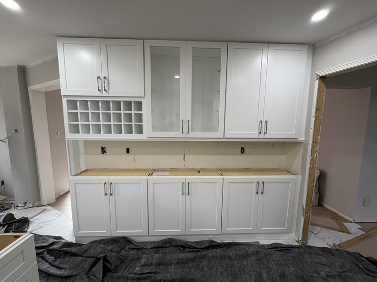 White cabinets with open display cubbies during installation