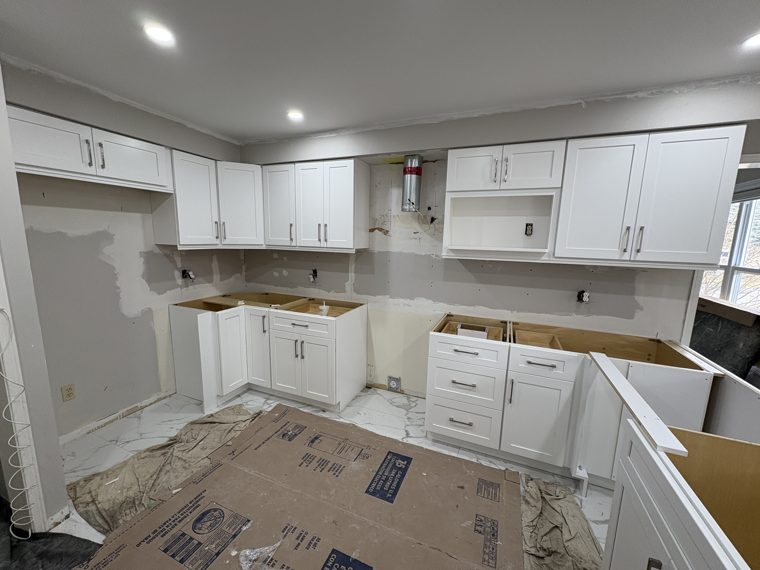 White kitchen cabinets and island on a working site