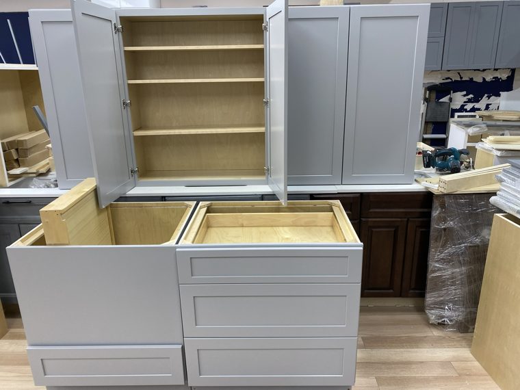 Grey cabinets with doors and drawers open