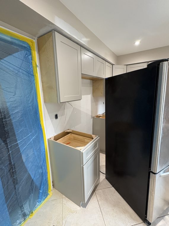Tall white cabinets beside a protected window