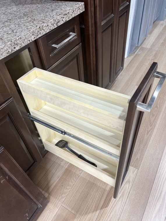 Open wooden drawer in a dark cabinet