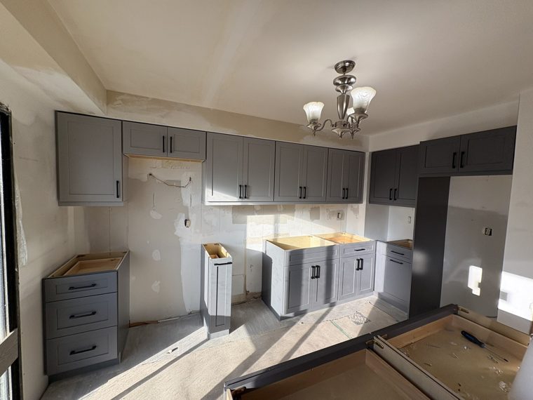 Grey kitchen cabinets during installation