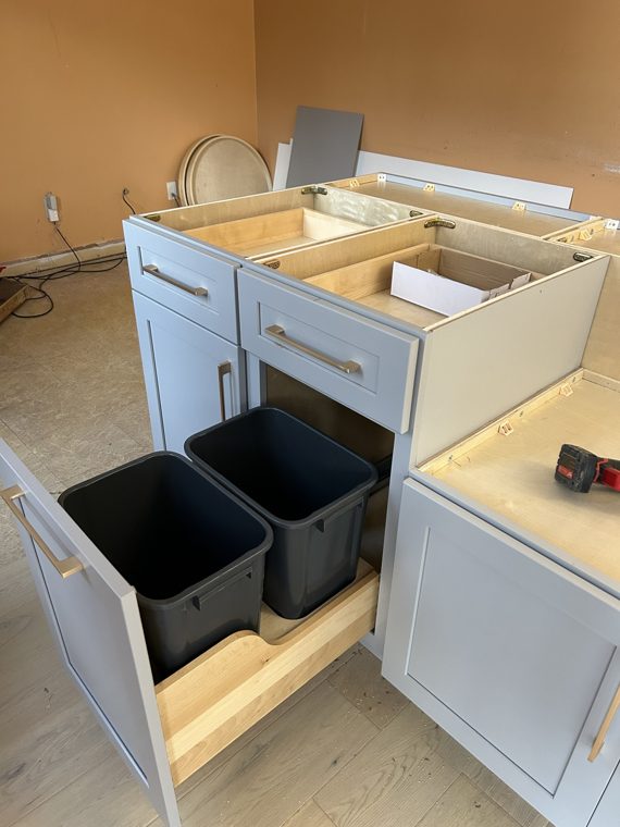 Pullout waste bins in a kitchen base cabinet