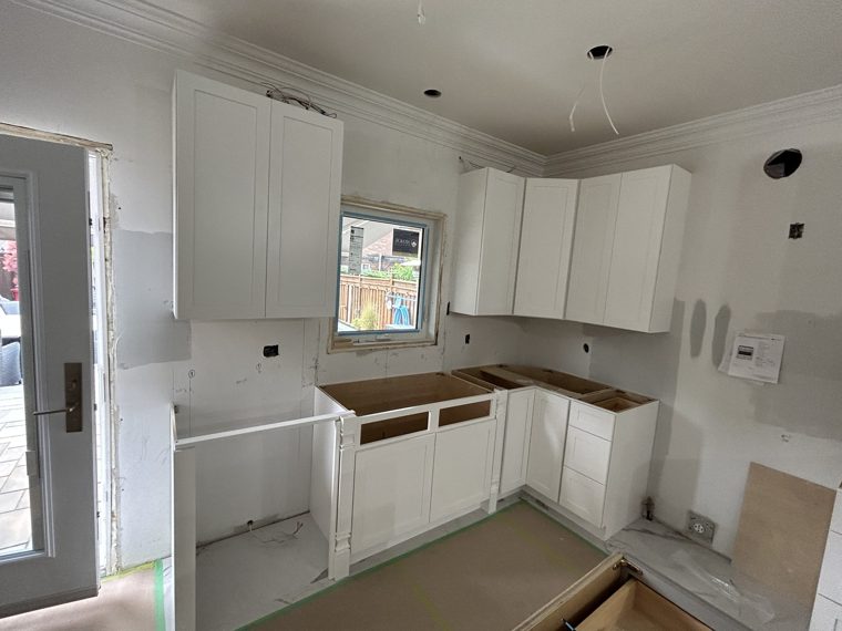 White kitchen cabinets being fitted